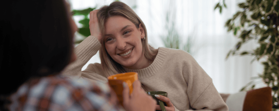 Two women share a warm conversation over coffee in a cozy setting